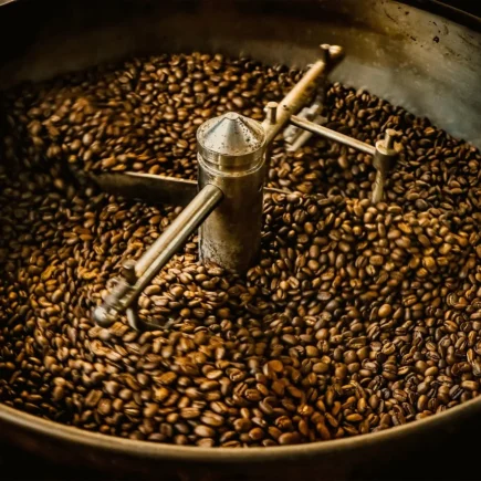 Misa z palonymi ziarnami kawy oraz mieszadło.